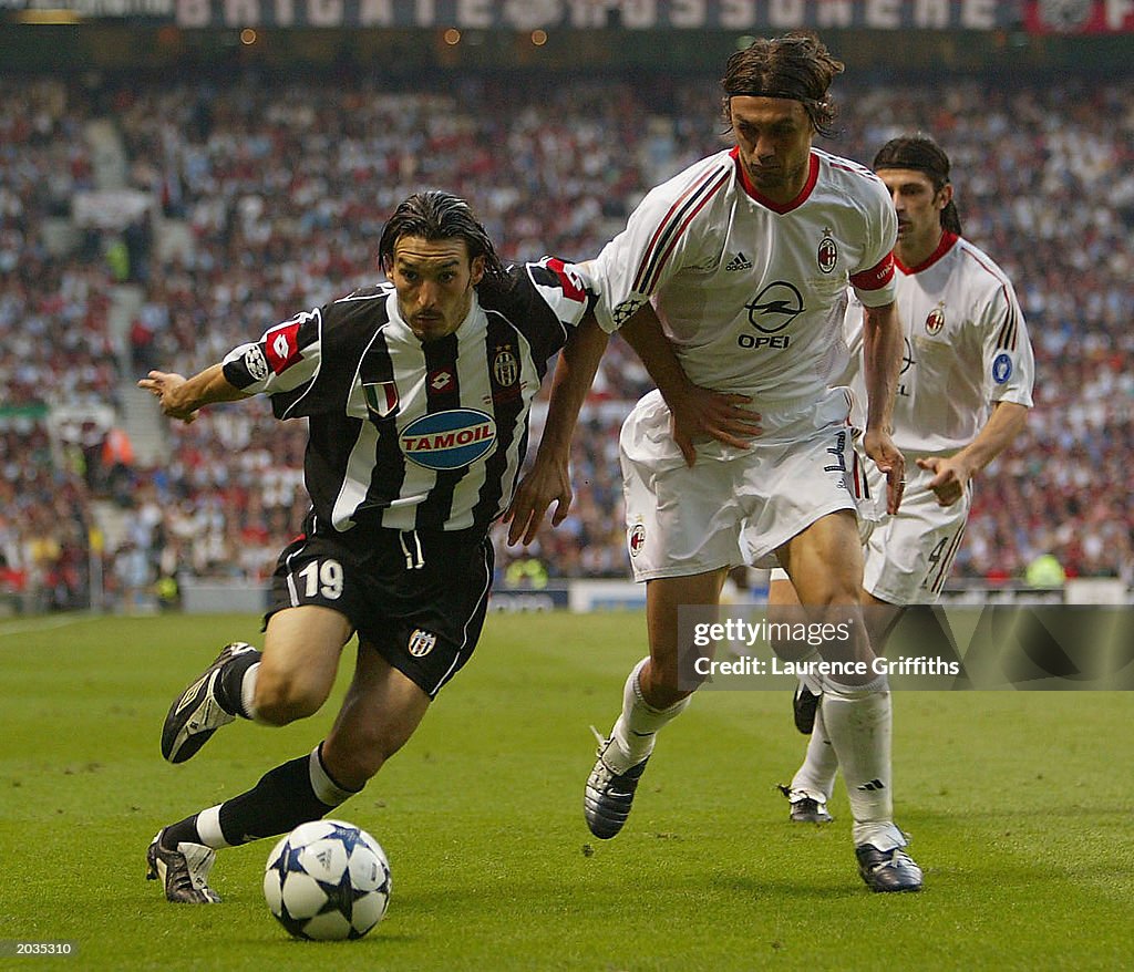 Paolo Maldini of Milan tries to tackle Gianluca Zambrotta of Juventus
