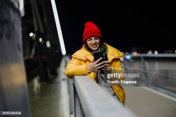 woman drinking beer and using smart phone - online happy hour stock pictures, royalty-free photos & images