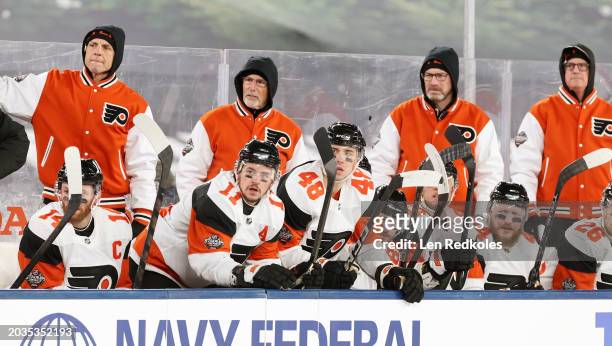 Head coach John Tortorella of the Philadelphia Flyers looks on with his coaching staff from behind the bench during the 2024 Navy Federal Credit...