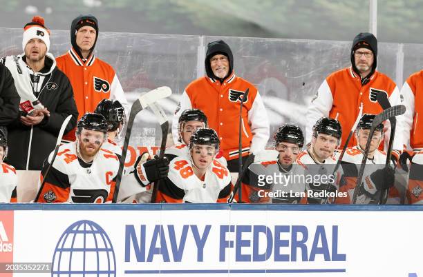 Head coach John Tortorella of the Philadelphia Flyers looks on with his coaching staff from behind the bench during the 2024 Navy Federal Credit...