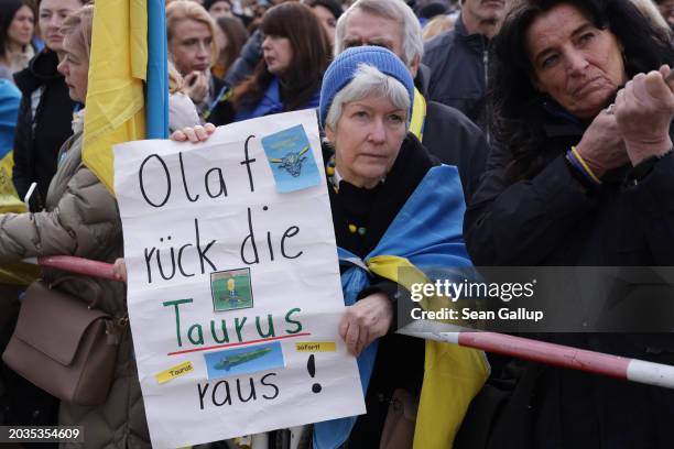 People, including one participant holding a placard that in German reads: "Olaf, release the Taurus!", in reference to demands on German Chancellor...