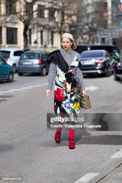 Chloe King is seen wearing a black and white polka dots printed hat, a black and white striped shirt, a black and flower printed scarf with the...