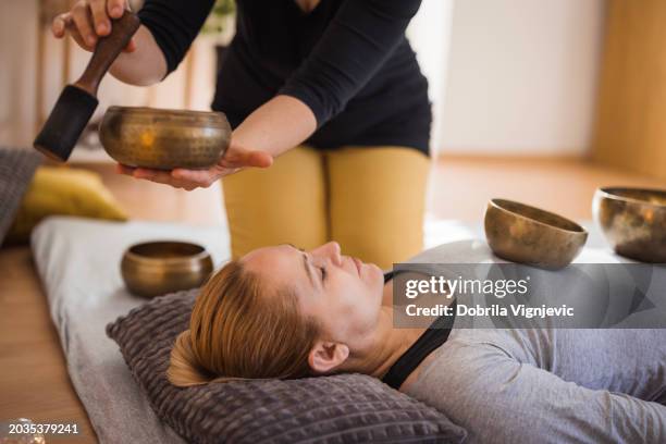 frequency therapy with tibetan singing bowls - medische procedure stockfoto's en -beelden