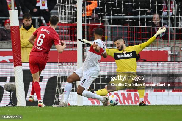 Eric Martel of 1.FC Koeln scores the team's first goal past Josha Vagnoman and goalkeeper Fabian Bredlow of VfB Stuttgart during the Bundesliga match...