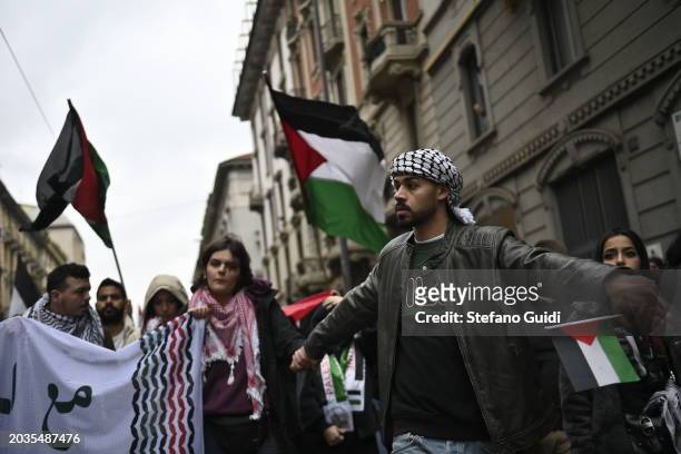 People hold a protest sign and Palestine flag during the Pro-Palestine Demonstration on February 24, 2024 in Milan, Italy. The war between Israel and...