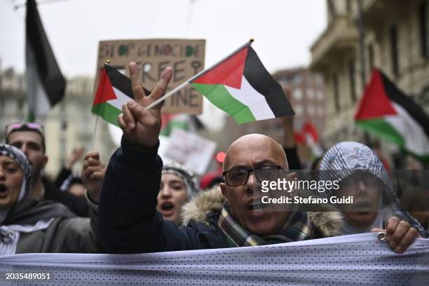 Man holds a Palestine flag and peace symbol on hand during the Pro-Palestine Demonstration on February 24, 2024 in Milan, Italy. The war between...