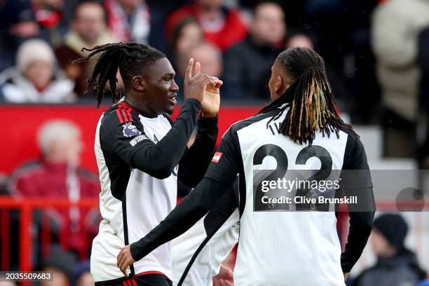 Calvin Bassey of Fulham celebrates scoring his team's first goal with teammate Alex Iwobi during the Premier League match between Manchester United...