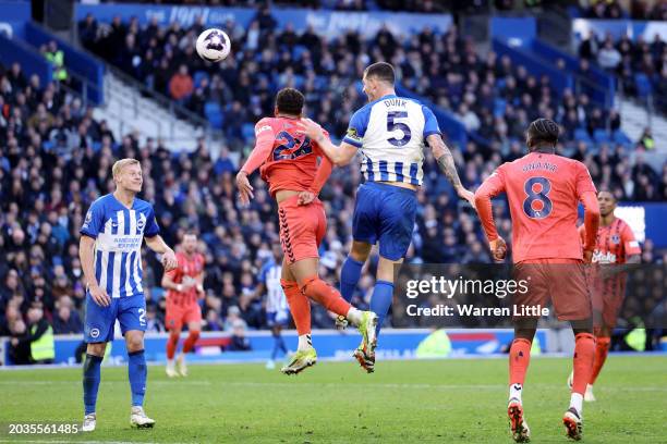 Lewis Dunk of Brighton & Hove Albion wins a header against Ben Godfrey of Everton and scores his team's first goal during the Premier League match...