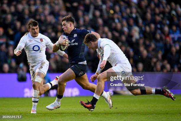 Huw Jones of Scotland runs with the ball whilst under pressure from George Furbank and Tommy Freeman of England during the Guinness Six Nations 2024...