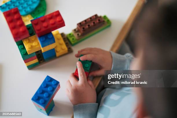 close-up of little boys building something with plastic blocks on the table. - endast en pojke bildbanksfoton och bilder