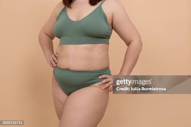 unidentifiable figure exuding confidence in seamless bikini, glorious obese woman keeping hands on hips, posing in studio. - exuding stock pictures, royalty-free photos & images