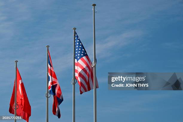 This photograph taken on February 27, 2024 shows an empty mast amongst member nation flags of the United States , Great Britain and Turkey in the...