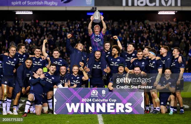 Dr James Robson MBE, Doctor of Scotland, is lifted by Pierre Schoeman as he lifts the Calcutta Cup as players of Scotland celebrate after defeating...