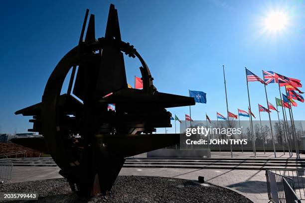 This photograph taken on February 27, 2024 shows an empty mast amongst member nation flags in the Cour d'Honneur of the NATO headquarters, ahead of a...