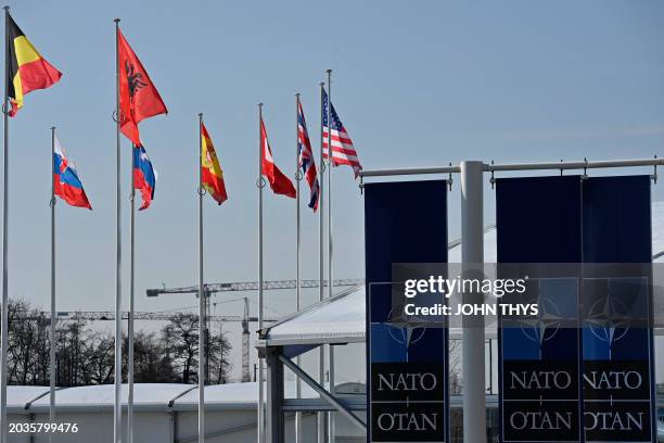 This photograph taken on February 27, 2024 shows an empty mast amongst member nation flags in the Cour d'Honneur of the NATO headquarters, ahead of a...