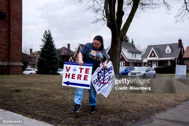 Volunteer places a "Vote Here" sign outside of a polling station at McDonald Elementary School in Dearborn, Michigan, US, on Tuesday, Feb. 27, 2024....