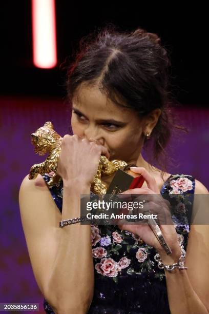 Mati Diop kisses the award on stage after winning the Golden Bear for Best Film for “Dahomey” at the Award Ceremony of the 74th Berlinale...