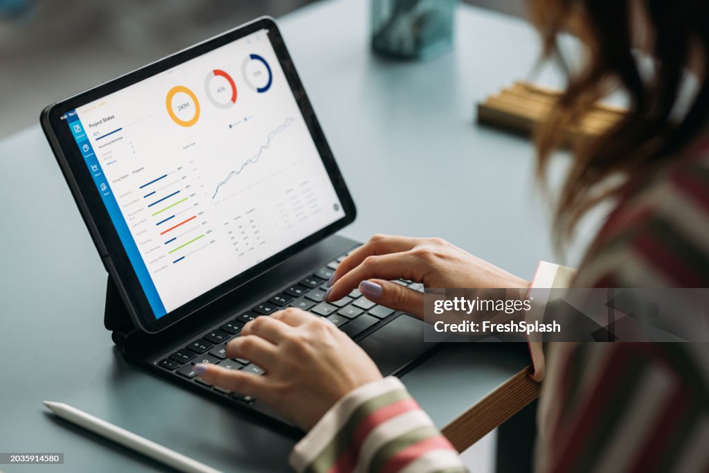 Mulher profissional analisando dados em tablet na mesa de trabalho