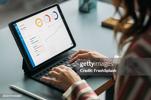 Professional Woman Analyzing Data on Tablet at Work Desk Professional Woman Analyzing Data on Tablet at Work Desk