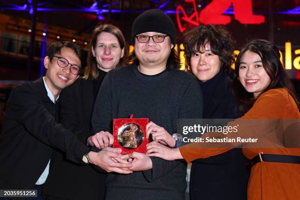 Qiu Yang and guests pose with his Encounters Special Jury Award for the movie "Kong fang jian li de nv ren" on the red carpet after the Award...