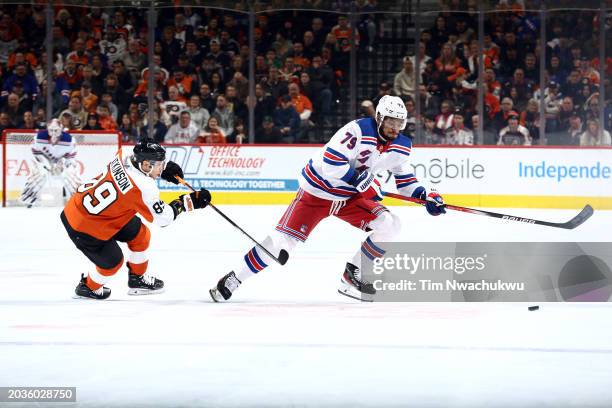Cam Atkinson of the Philadelphia Flyers and K'Andre Miller of the New York Rangers challenge for the puck during the first period at the Wells Fargo...