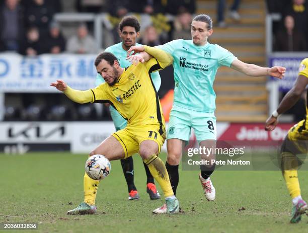 Ben Fox of Northampton Town contests the ball with Mason Bennett of Burton Albio during the Sky Bet League One match between Burton Albion and...