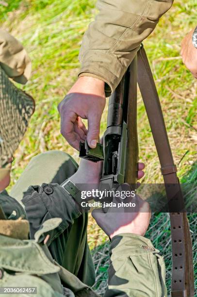 persons wearing outdoor clothing is meticulously cleaning a rifle - air gun stock pictures, royalty-free photos & images