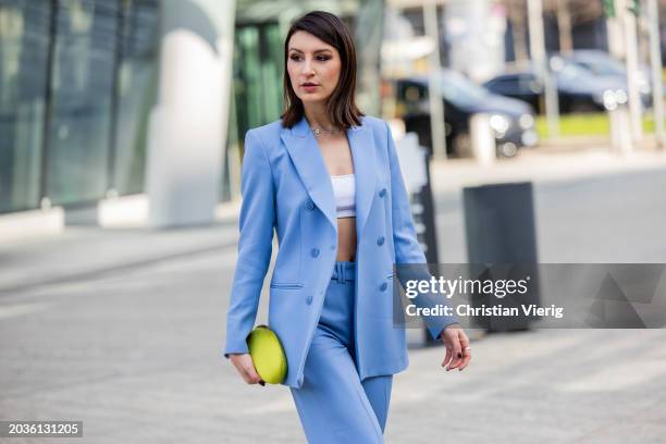 Guest wears blue suit, yellow bag outside Ermanno Scervino during the Milan Fashion Week - Womenswear Fall/Winter 2024-2025 on February 24, 2024 in...