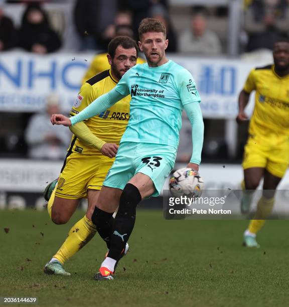 Patrick Brough of Northampton Town plays the ball away from Mason Bennett of Burton Albio during the Sky Bet League One match between Burton Albion...