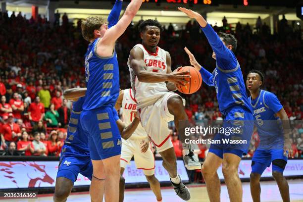 Jamal Mashburn Jr. #5 of the New Mexico Lobos drives and looks to pass against Luke Kearney and Beau Becker of the Air Force Falcons during the...