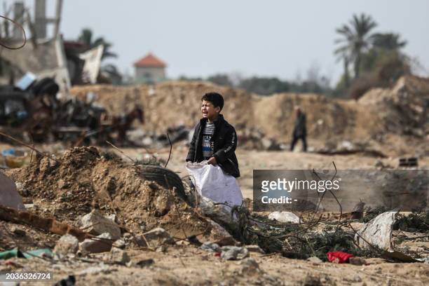 Palestinian boy cries as he stands amid debris in the Maghazi camp for Palestinian refugees, which was severely damaged by Israeli bombardment amid...