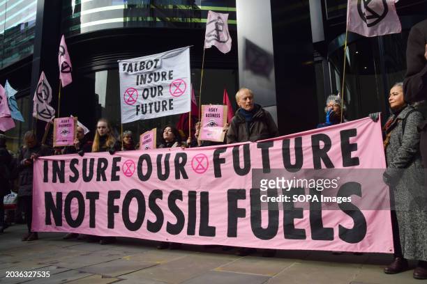 Protesters hold a banner opposed to insurance of fossil fuels during the demonstration outside Talbot Insurance offices. Extinction Rebellion...