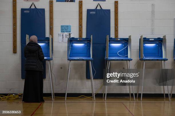 People vote at a voting site as Democrats and Republicans hold their Michigan primary presidential election in Dearborn, Michigan, United States on...