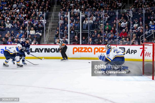 Kyle Connor of the Winnipeg Jets shoots the puck towards the net as goaltender Joel Hofer of the St. Louis Blues guards the crease during first...