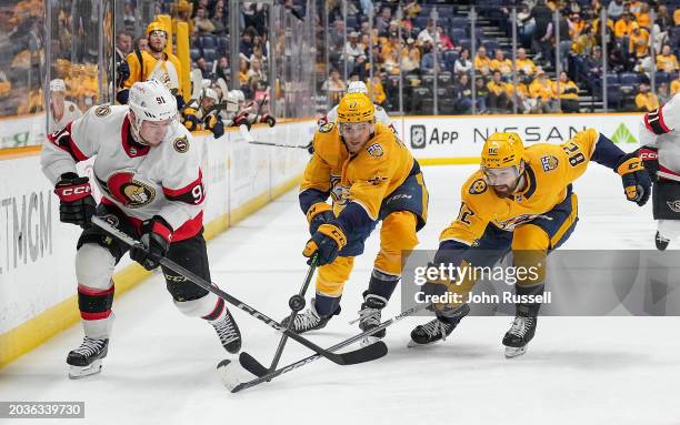 Vladimir Tarasenko of the Ottawa Senators battles for the puck against Mark Jankowski and Tommy Novak of the Nashville Predators during an NHL game...