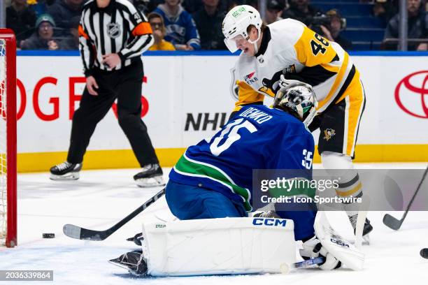 Pittsburgh Penguins right wing Valtteri Puustinen just misses the puck as Vancouver Canucks goaltender Thatcher Demko watches during an NHL game...