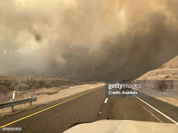 Smoke rises on the roadway in Hutchinson County after the Juliet Pass fire broke out in Armstrong County, Texas, United States on February 28, 2024.