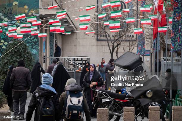 Veiled woman is walking under Iranian flags in southern Tehran, Iran, on February 27 amid the Parliamentary election campaigns. The elections for the...