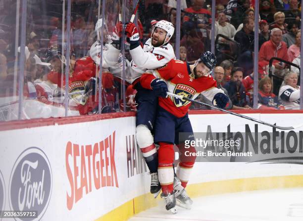 Oliver Ekman-Larsson of the Florida Panthers checks Tom Wilson of the Washington Capitals into the boards during the first period at Amerant Bank...