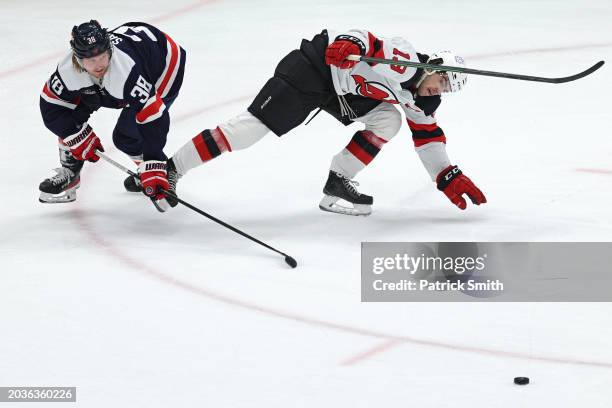 Nico Hischier of the New Jersey Devils and Rasmus Sandin of the Washington Capitals battle for the puck during the second period at Capital One Arena...