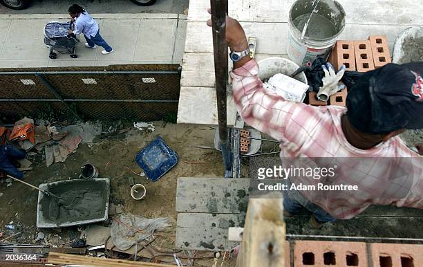 Bricklayers take a brake from to build a Habitat for Humanity house May 28, 2003 in Bronx neighborhood of New York City. Habitat for Humanity is...