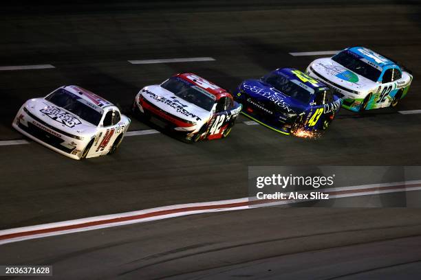 Ryan Ellis, driver of the Classic Collision Chevrolet, drives with sparks inline with JJ Yeley, driver of the SS GreenLight Racing Chevrolet, Leland...