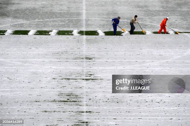 Ground staffs remove snow prior to the J.League J1 match between Albirex Niigata and Cerezo Osaka at Denka Big Swan Stadium on December 2, 2017 in...