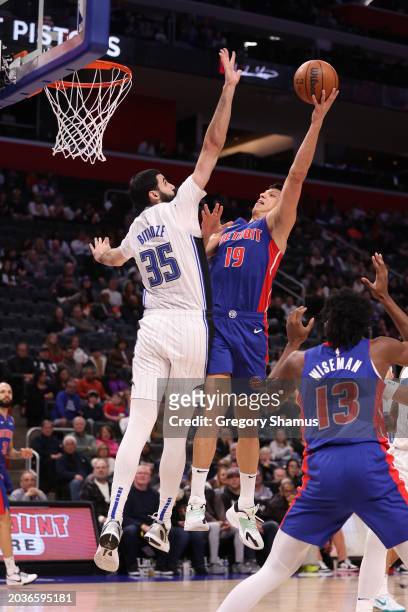 Simone Fontecchio of the Detroit Pistons drives to the basket against Goga Bitadze of the Orlando Magic during the first half at Little Caesars Arena...