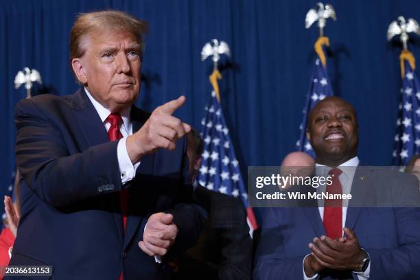 Republican presidential candidate and former President Donald Trump gestures to supporters as Sen. Tim Scott looks on during an election night watch...