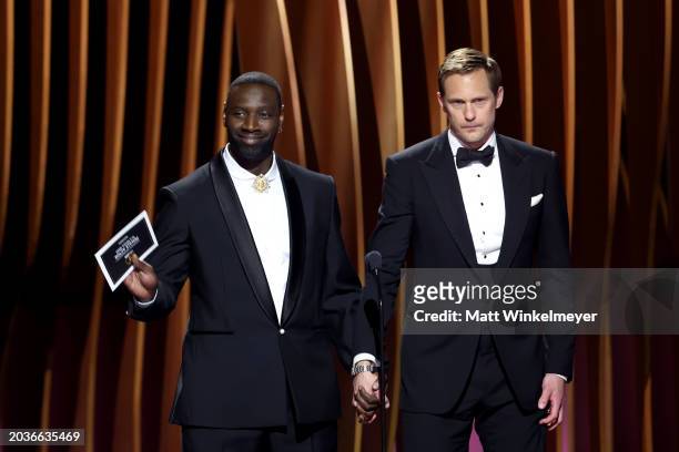 Omar Sy and Alexander Skarsgård speak onstage during the 30th Annual Screen Actors Guild Awards at Shrine Auditorium and Expo Hall on February 24,...