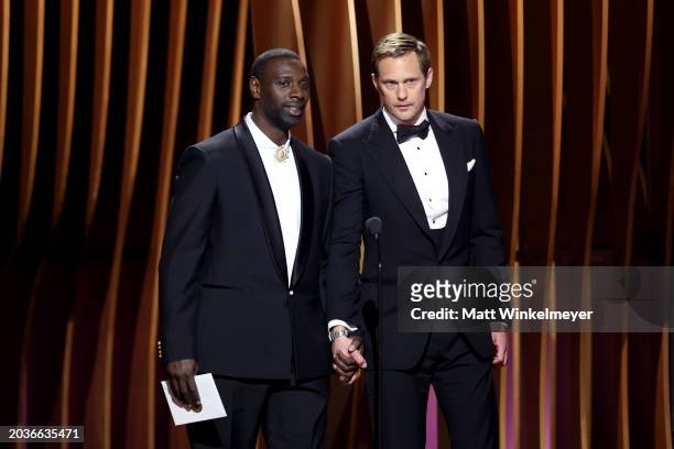 Omar Sy and Alexander Skarsgård speak onstage during the 30th Annual Screen Actors Guild Awards at Shrine Auditorium and Expo Hall on February 24,...