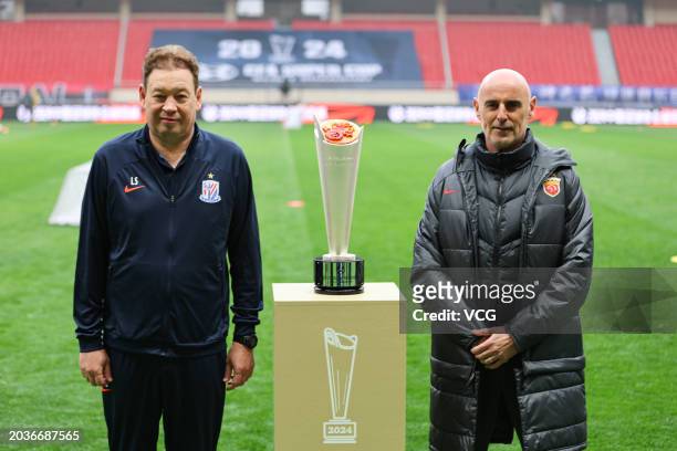 Head coach Leonid Slutsky of Shanghai Shenhua and head coach Kevin Vincent Muscat of Shanghai Port pose beside a trophy ahead of the 2024 Chinese...