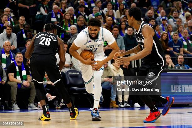 Karl-Anthony Towns of the Minnesota Timberwolves drives to the basket against Dorian Finney-Smith and Nic Claxton of the Brooklyn Nets in the second...