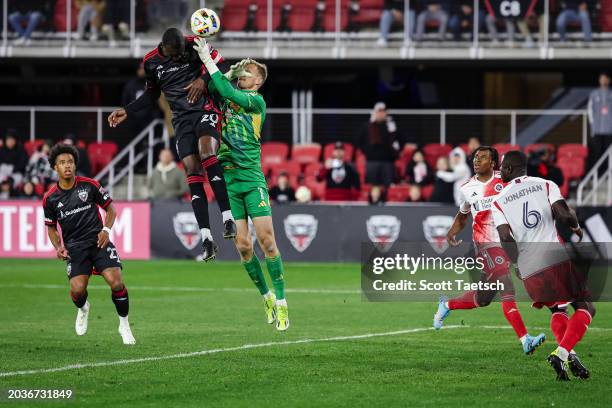 Christian Benteke of D.C. United heads the ball to score his third goal of the MLS game against Henrich Ravas of New England Revolution during the...